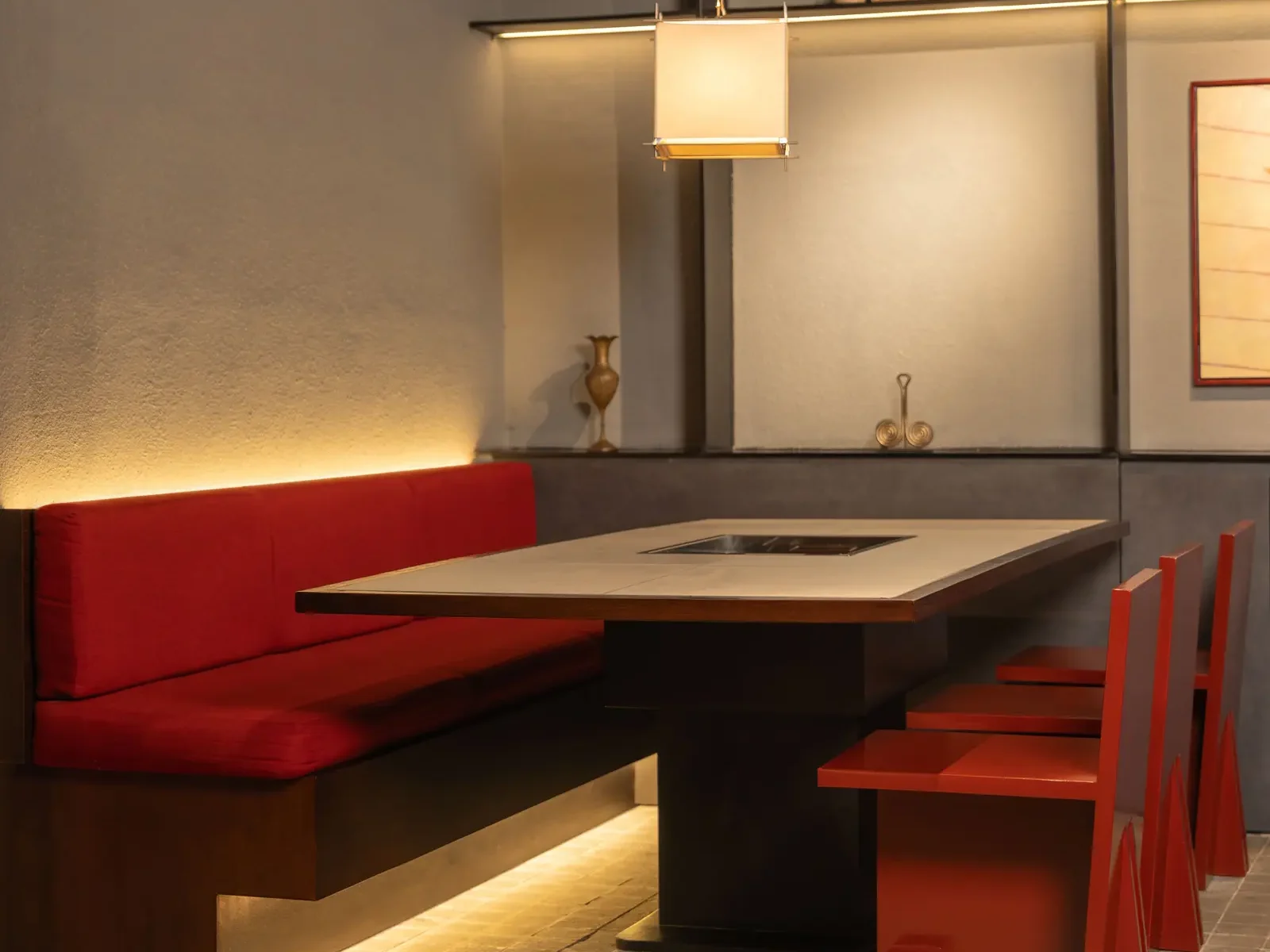 Cozy red booth seating inside a japanese restaurant in Ubud, with warm and authentic ambiance for group dining.