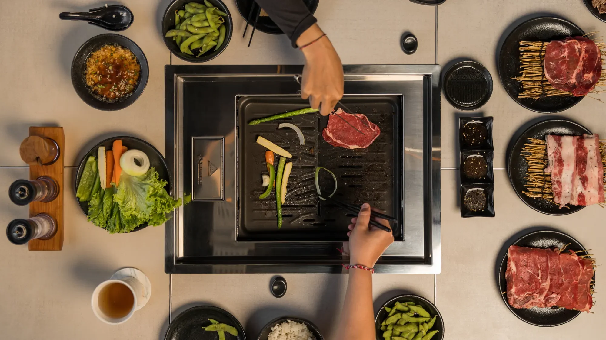 Japanese food Ubud served at Raku Raku Yakiniku, featuring grilled meat and traditional side dishes