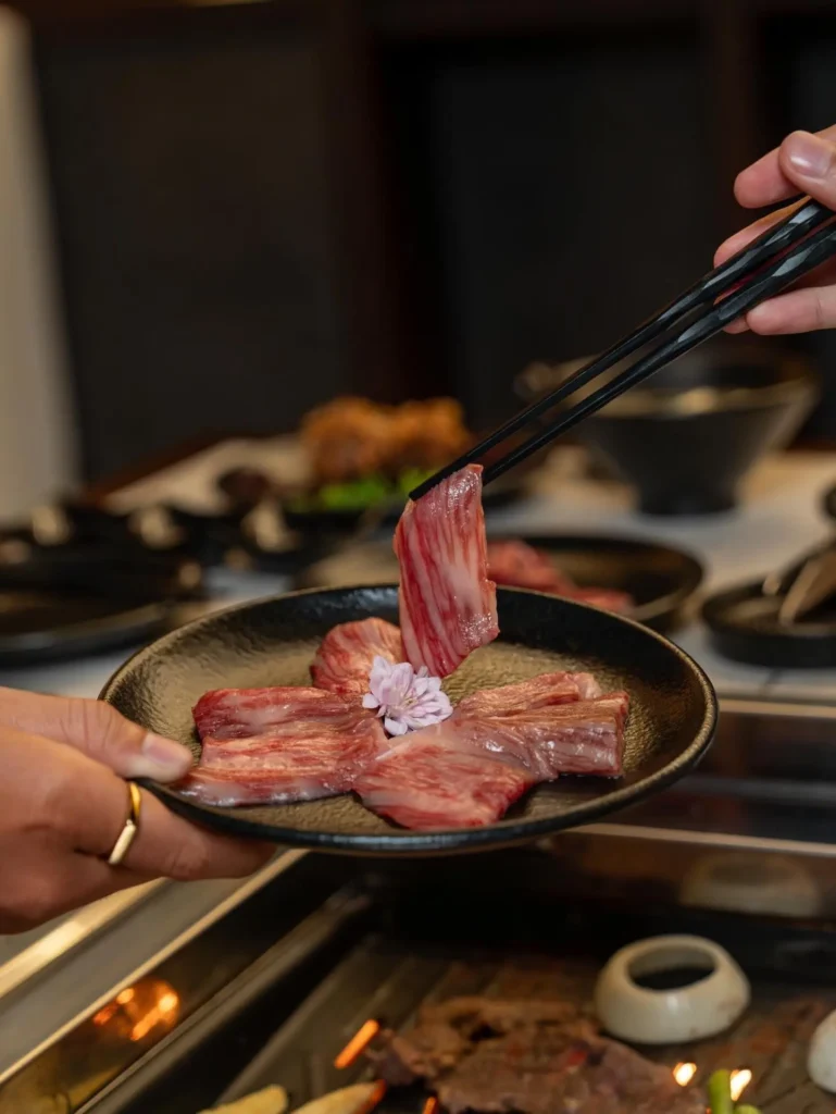Spread of grilled meats and sides for a group at Raku Raku Yakiniku